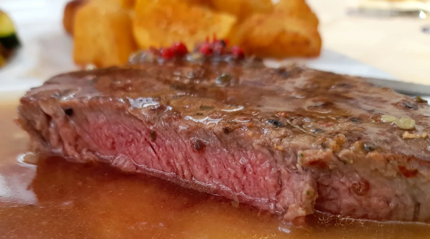 Frisch gegrilltes Steak mit Beilagen im Restaurant in Alland